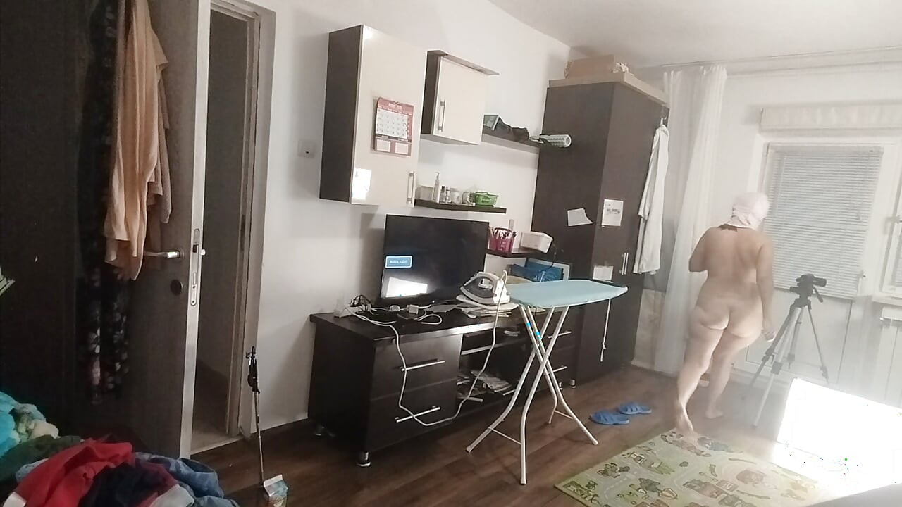 Sexy brunette doing naked chores around the house.