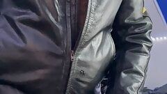 Un mec barbu en veste en cuir baise son gant en cuir