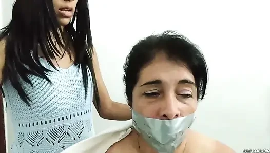 Lezbiyen orta yaşlı seksi kadın partnerleri çıplak bağlı, şaplak atılıyor ve genç kız tarafından ağzı tıkanıyor