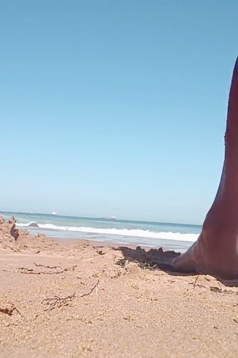 A Young Person Spreads Their Buttocks Apart on the Beach While Others Watch.
