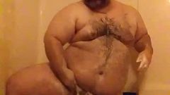 Uomo paffuto sotto la doccia
