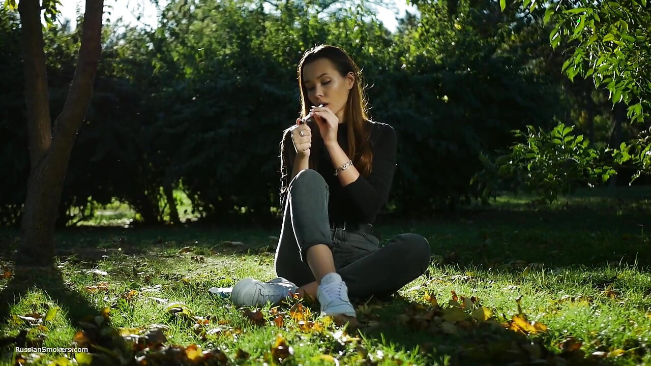 Seductora belleza rusa fumando cigarrillos al aire libre