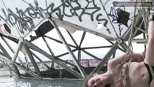 Blondes schätzchen wird gefesselt und mit seilen aufgehängt