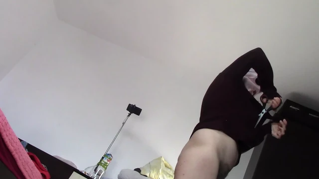 Amateur wife dancing naked at home. Amateur woman has fun trying on clothes and cutting them.