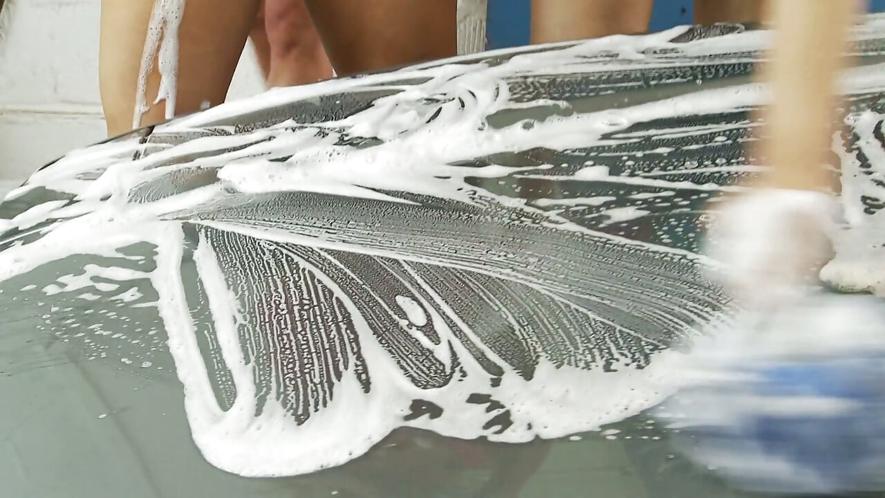 Three hot girls get horny during a car wash and fuck with a dildo