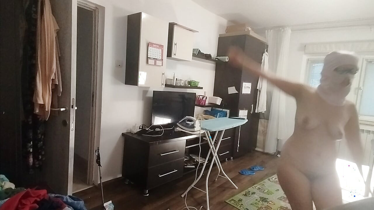 性感的黑发女郎在房子里做裸体家务