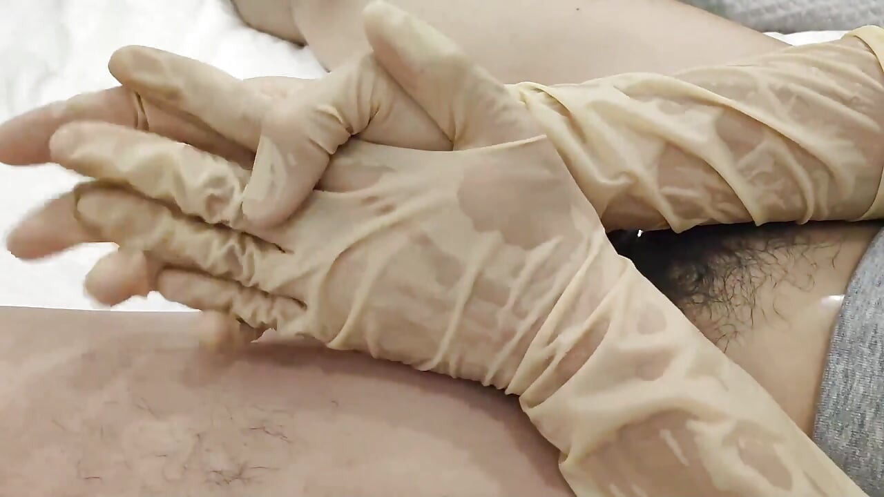 Latex glove play with sheathed cock