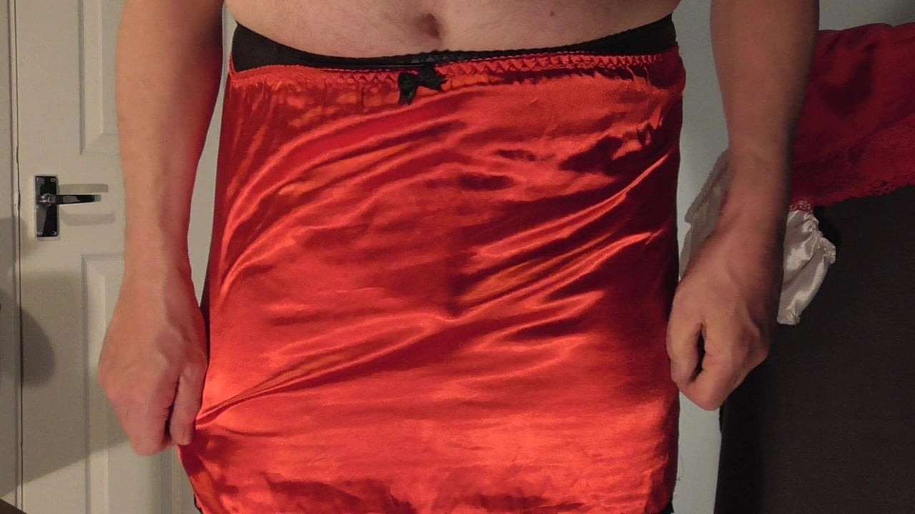 Showing  pink panties with red stockings and red satin slip