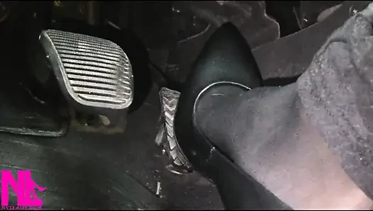 Menyadarkan dan mengemudi dengan stoking hitam dan sepatu hak tinggi abu-abu