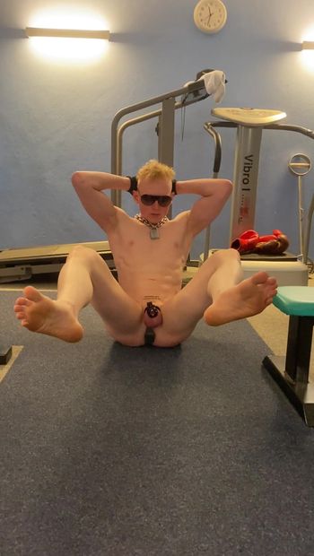 Locked plugged naked slave doing a workout