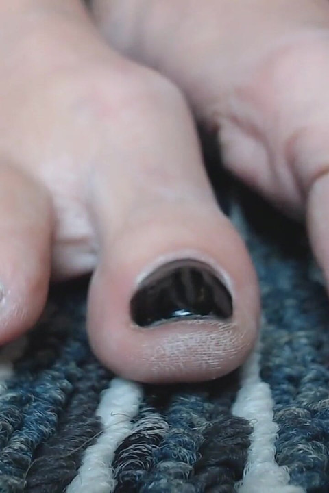 เล่นเล็บเท้าสีดําแบบโคลสอัพ