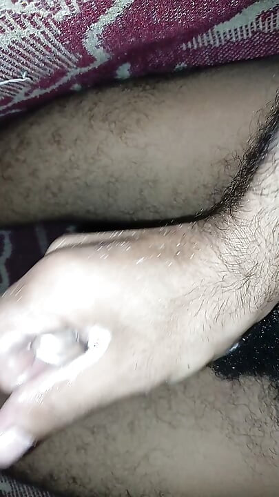 Handsome young man masturbating his large cock without a condom - twink with a big dick - stroking a black cock.