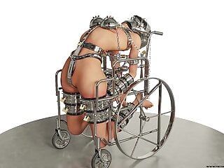 Schiavo hardcore ammanettato e incatenato in un bondage in metallo su sedia a rotelle