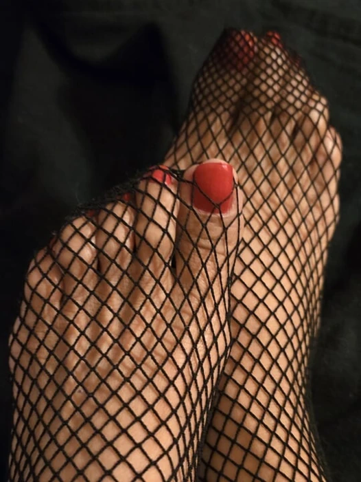 Tiny feet in fishnet stocking...red toe nails