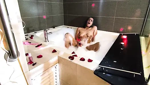 Köpük ve gül yaprakları ile küvette romantik ve ıslak mastürbasyon.