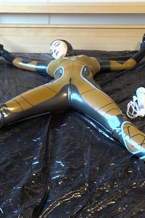 Latexová Danielle je připevněna k posteli a masturbuje s masážním vibrátorem