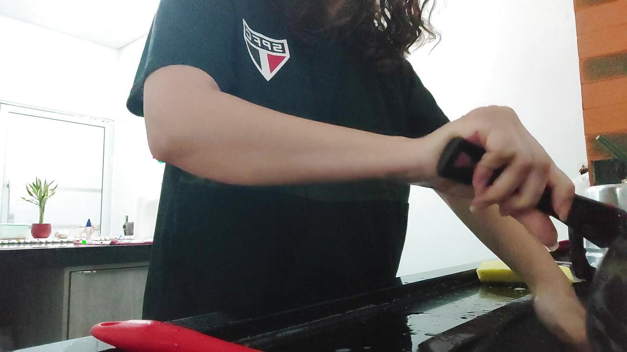 Woman teasing while washing dishes. She loves to transmit to the voyeurs on duty