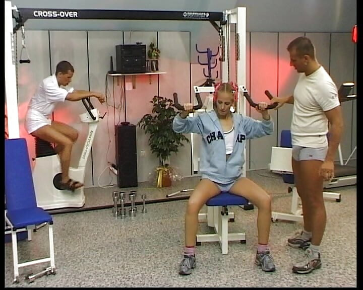 Petite blonde German babe rides two dicks in the gym