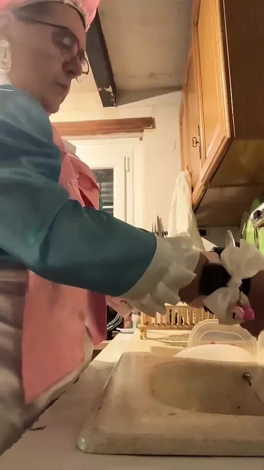 In a blue maid's outfit with pink bows to do the dishes.