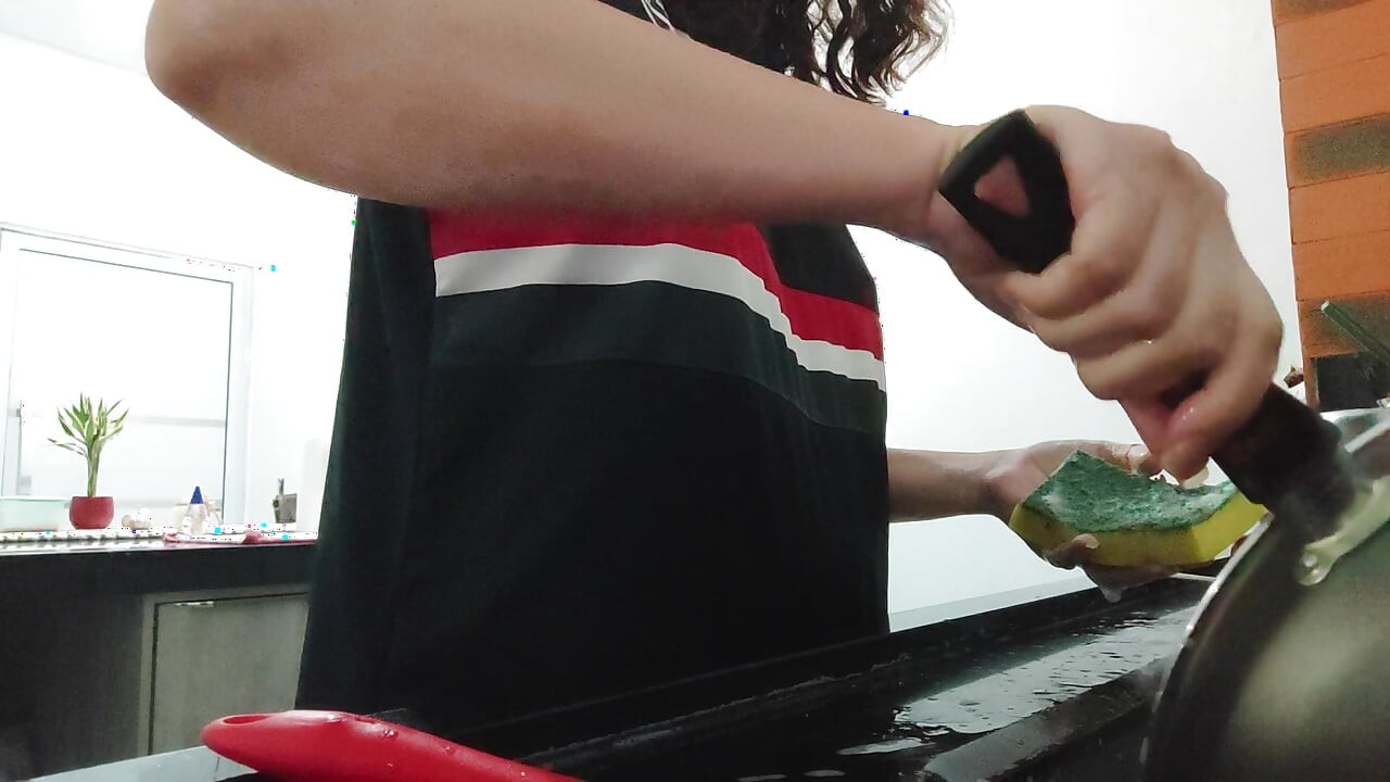 Woman teasing while washing dishes. She loves to transmit to the voyeurs on duty