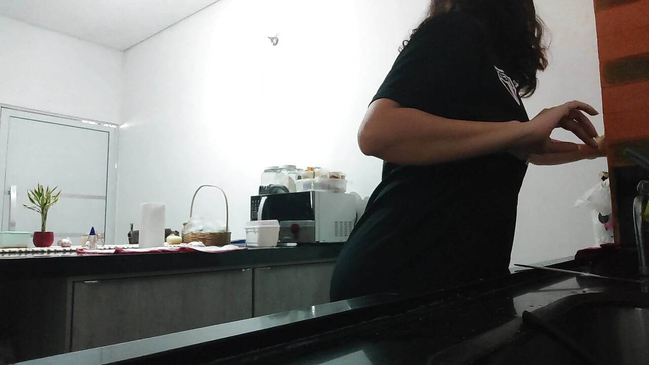 Woman teasing while washing dishes. She loves to transmit to the voyeurs on duty