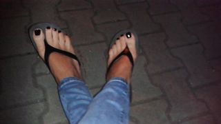 Esmalte de uñas negro brillante y chanclas de plataforma