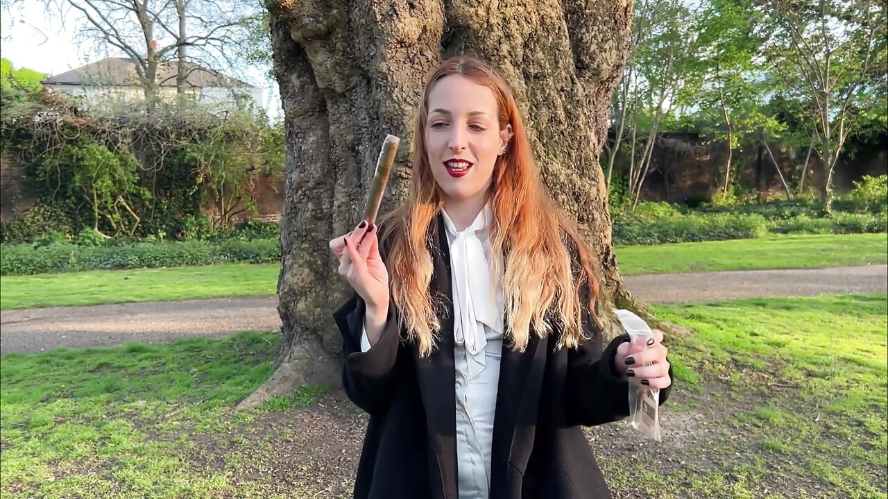 Liz Duga puši cigaru flor de Oliva na otvorenom