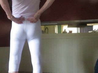 肌にきつい白いスパンデックスのレギンスを履いた男性痴女。