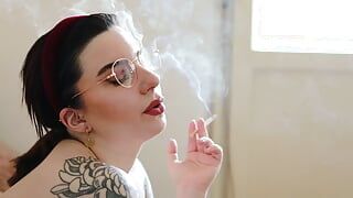 Une modèle tatouée nue fume une cigarette camel s100