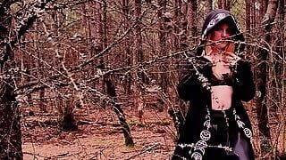 Safada bruxa está brincando com um vibrador na floresta