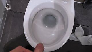 Mann pisst in den öffentlichen Toiletten während der Arbeitszeit