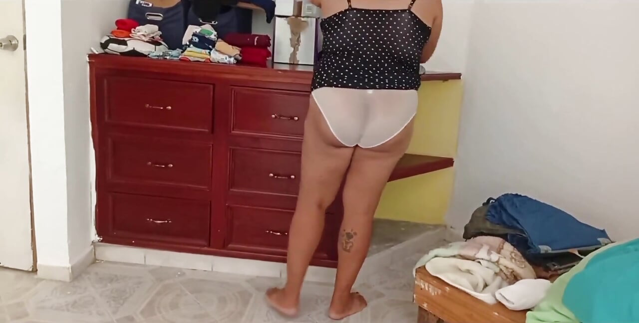 Fată dolofană care leagă camera și își pliază hainele