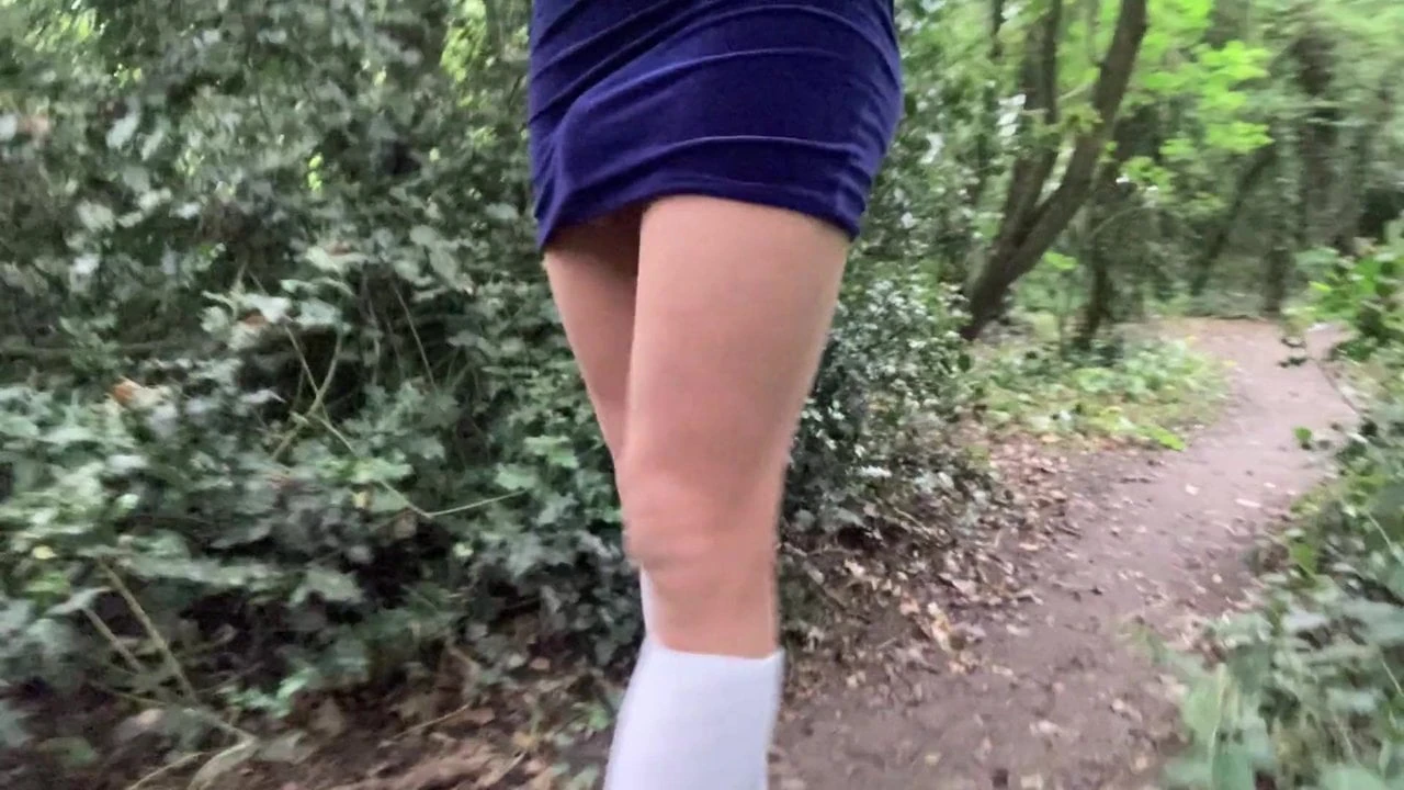 Walk in the woods in velvet dress and white socks .