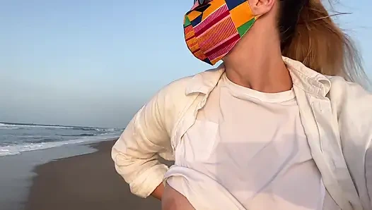 Pirang dengan payudara besar tanpa bra berjalan di jalan