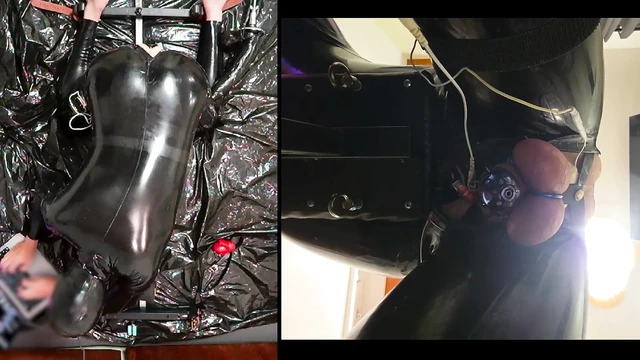 Session in the pillory with Latex Catsuit, PA Chastity, Giant Didildo and Estim