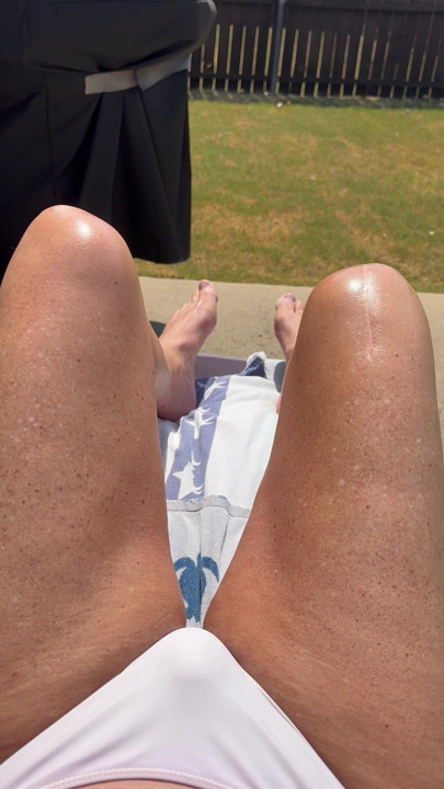 Sissy Cryssi tanning in a bikini with her long sexy legs