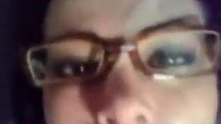 Девушка в очках получает камшот на лицо из большого черного члена