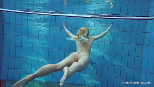 Une blonde russe parfaite nage dans la piscine
