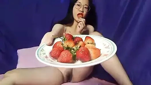セクシーな裸の女の子がマンコを見せ、オナニーしてイチゴを食べる