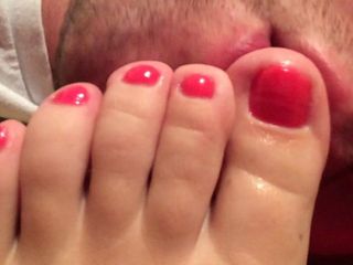 Chupando os belos dedos dos pés vermelhos da minha esposa