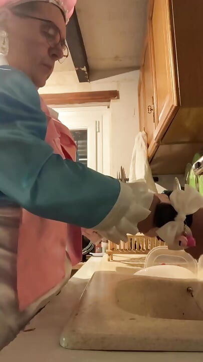 In a blue maid's outfit with pink bows to do the dishes.