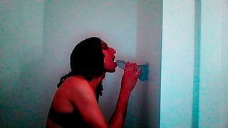 Миниатюрная транссексуалка с любовью сосет дилдо на стене