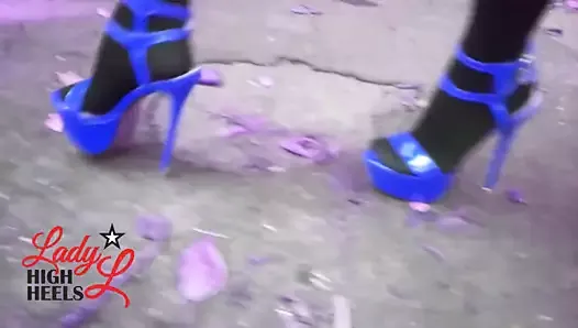 性感的女士穿着蓝色高跟鞋走路。