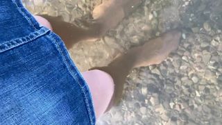 Crossdresser em meia-calça multicamadas caminhando em um lago
