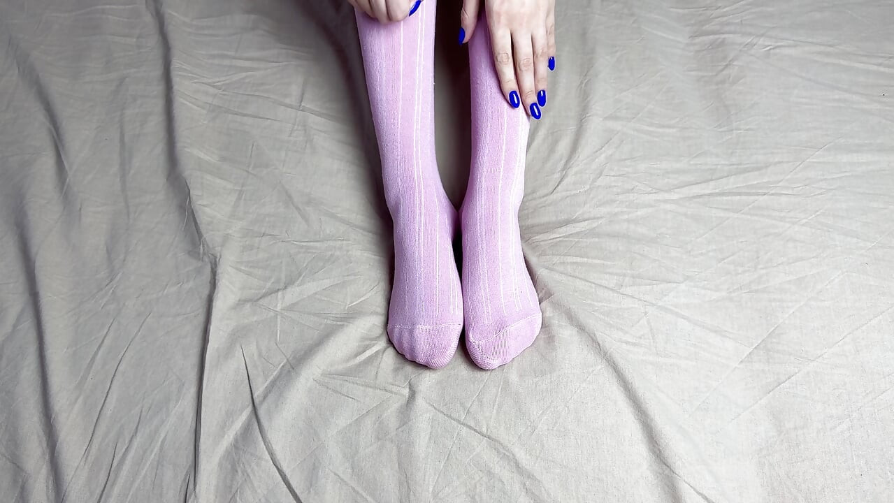 Pink socks in hands of mistress with blue nails in solo video