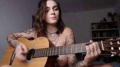 Une fille emo à forte poitrine joue à un jeu pervers à la guitare