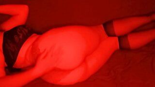 打开台灯上的红色模式并开始在婴儿床上穿着内衣和丝袜随着音乐拍摄