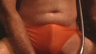 タイトなオレンジ色のビキニ水着シャワー