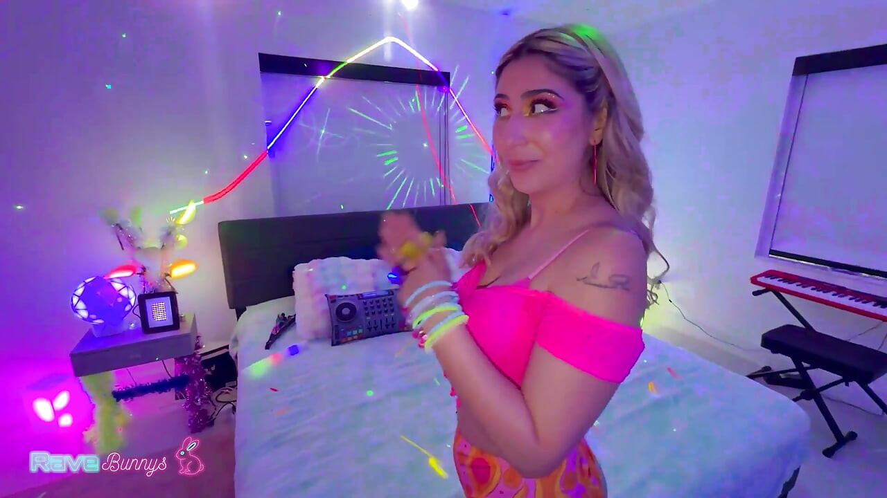 Dahlia Noire returns to Brian Omally's neon bedroom in pink fishnets, teasing a glowing anal plug before deepthroating him, ridi