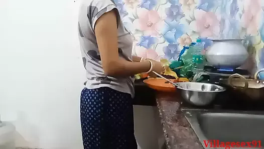 Жена в красном сари на кухне